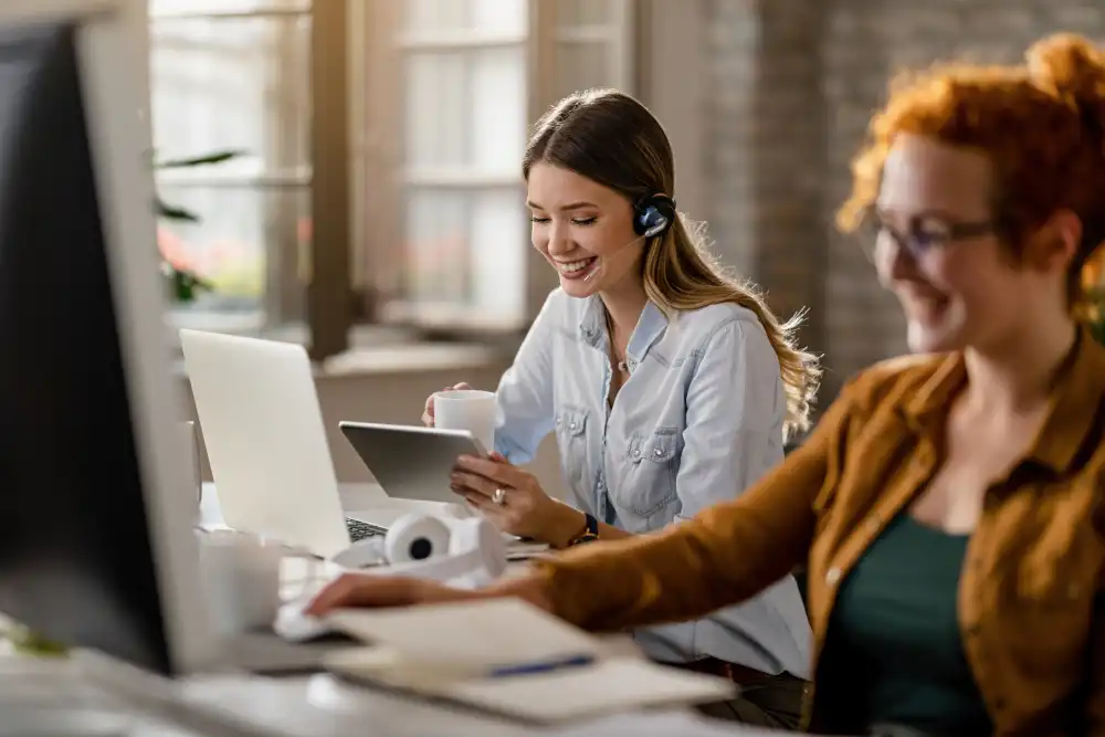 Atendente com fone de ouvido e xícara na mão atende cliente sorrindo